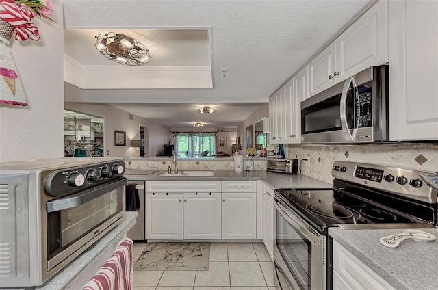 kitchen with backsplash, white cabinetry, sink, and appliances with stainless steel finishes