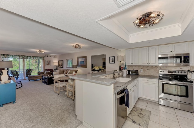 kitchen with white cabinetry, sink, kitchen peninsula, light tile patterned floors, and appliances with stainless steel finishes