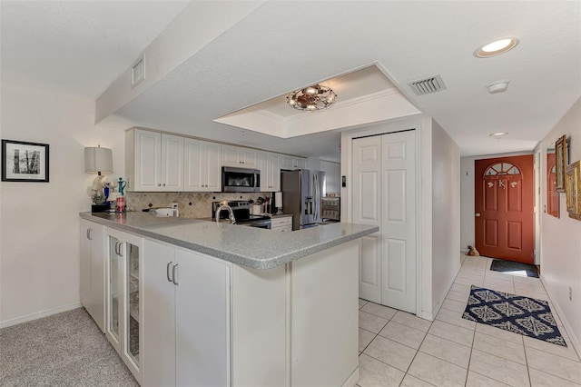 kitchen with kitchen peninsula, white cabinetry, stainless steel appliances, and light tile patterned floors