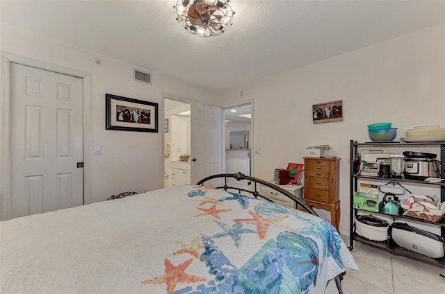 bedroom with light tile patterned flooring and connected bathroom