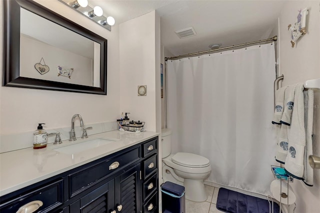 bathroom with toilet, vanity, and tile patterned floors