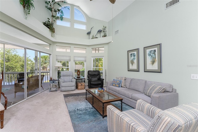 carpeted living room featuring a high ceiling and ceiling fan