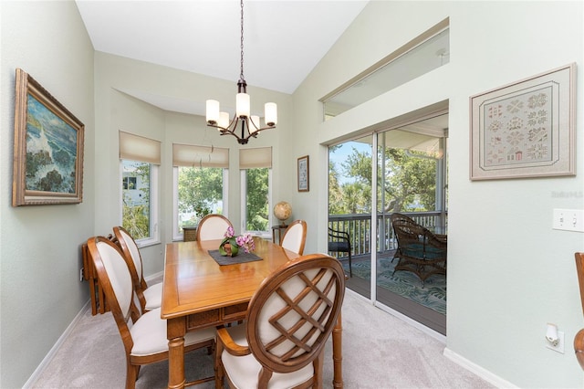 carpeted dining area with a chandelier and vaulted ceiling