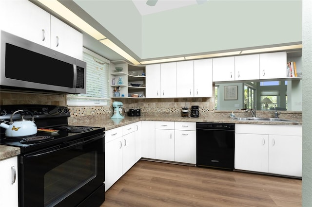 kitchen with black appliances, white cabinets, sink, decorative backsplash, and wood-type flooring