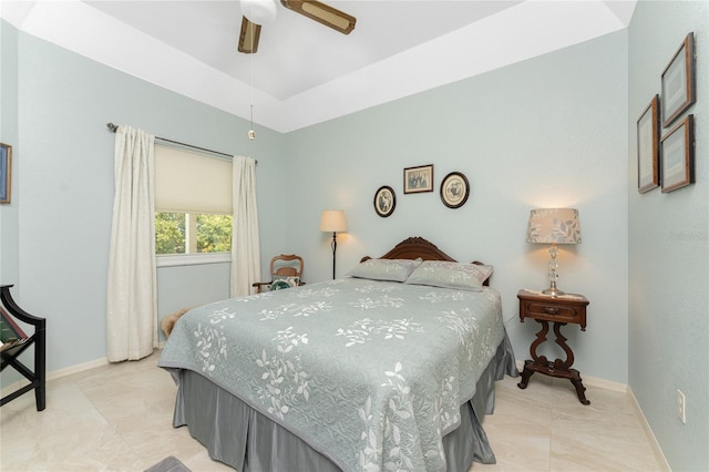 bedroom with a raised ceiling and ceiling fan