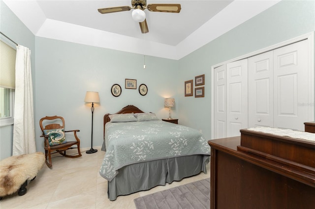 bedroom featuring a closet, a raised ceiling, and ceiling fan