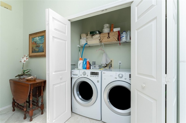 laundry room with washer and clothes dryer and light tile patterned floors