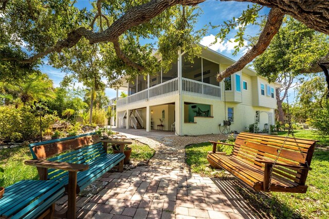 rear view of property featuring a sunroom and a patio area