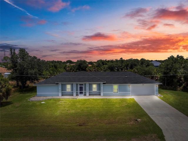 ranch-style home with a garage and a lawn