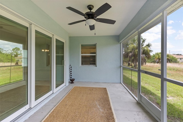 unfurnished sunroom featuring ceiling fan