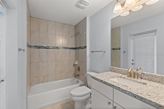 full bathroom featuring tile patterned flooring, vanity, tiled shower / bath combo, and toilet