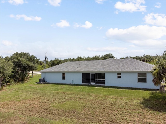 back of property featuring central AC and a yard