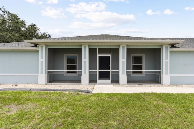 rear view of property featuring a sunroom and a yard