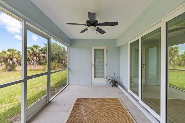 unfurnished sunroom with ceiling fan