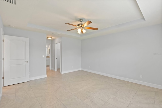 unfurnished room with a raised ceiling and ceiling fan