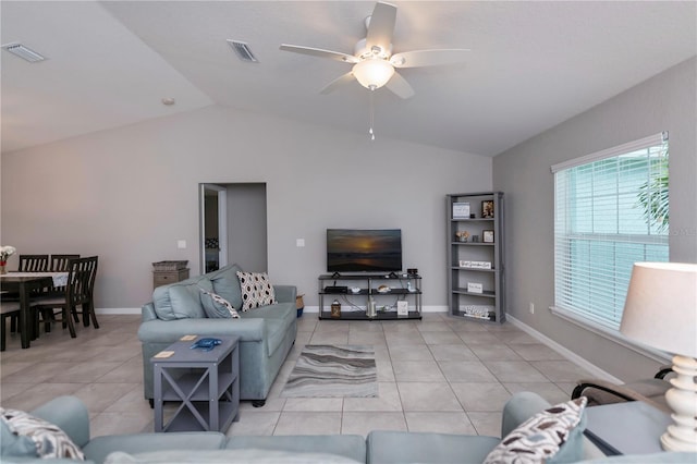 living room featuring ceiling fan, lofted ceiling, and light tile patterned floors