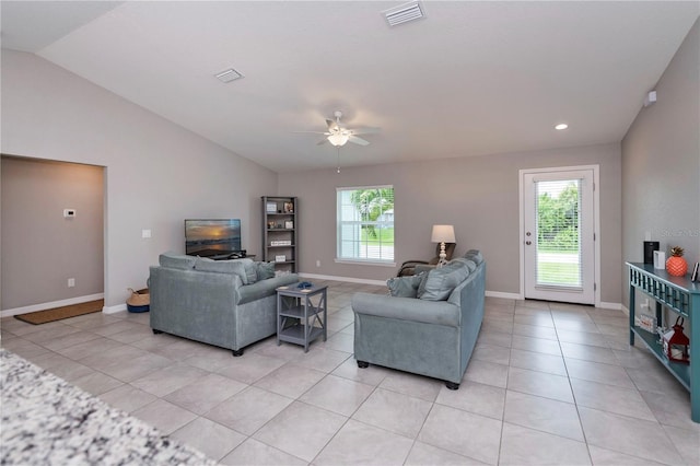 living room with a wealth of natural light, light tile patterned floors, ceiling fan, and lofted ceiling