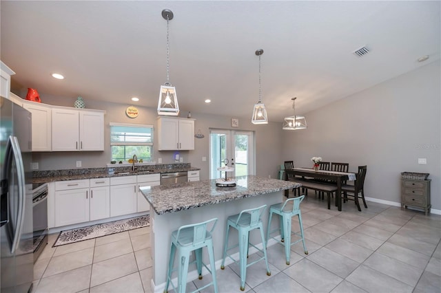 kitchen featuring sink, french doors, a kitchen island, pendant lighting, and white cabinets