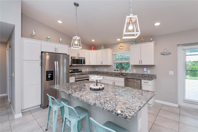 kitchen with white cabinetry, a kitchen island, lofted ceiling, and appliances with stainless steel finishes