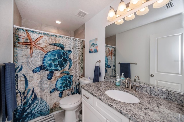 bathroom featuring tile patterned flooring, vanity, a textured ceiling, and toilet