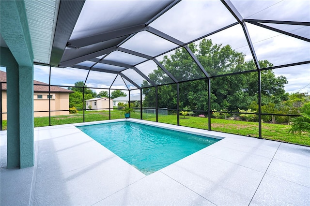 view of pool featuring a yard, glass enclosure, and a patio area