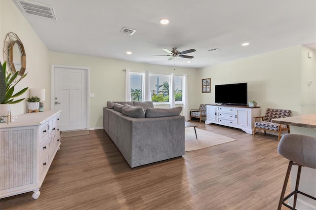 living room with ceiling fan and dark hardwood / wood-style flooring