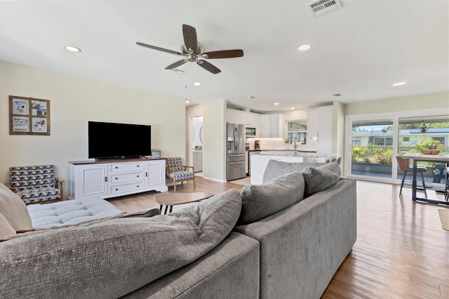 living room with ceiling fan and light wood-type flooring