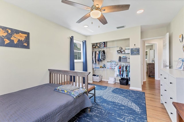 bedroom with light wood-type flooring, a closet, and ceiling fan