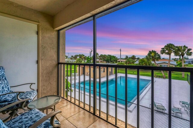 balcony at dusk with a fenced in pool