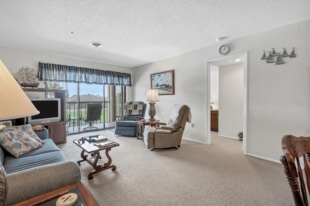 carpeted living room featuring a textured ceiling