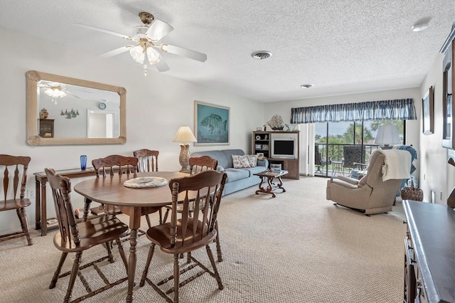 carpeted dining room with ceiling fan and a textured ceiling