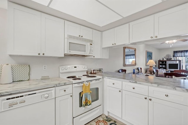 kitchen with a wealth of natural light, white cabinets, and white appliances