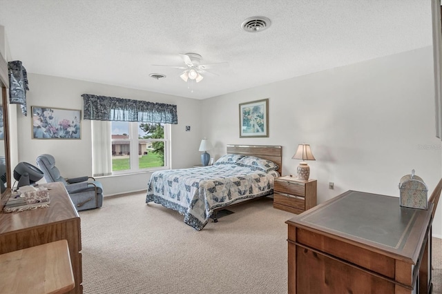 carpeted bedroom featuring ceiling fan and a textured ceiling