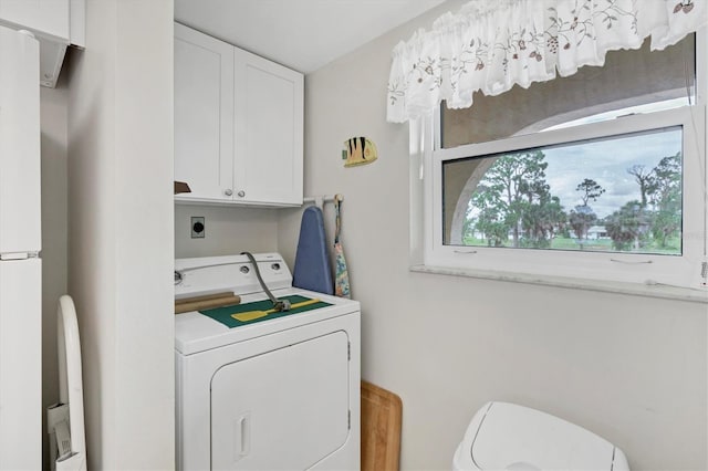 laundry area featuring separate washer and dryer and cabinets