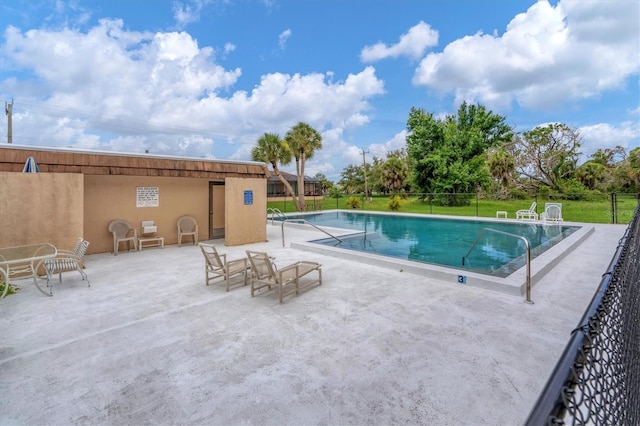 view of swimming pool featuring a patio area and a lawn