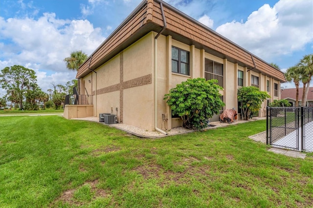 view of side of property featuring cooling unit and a lawn