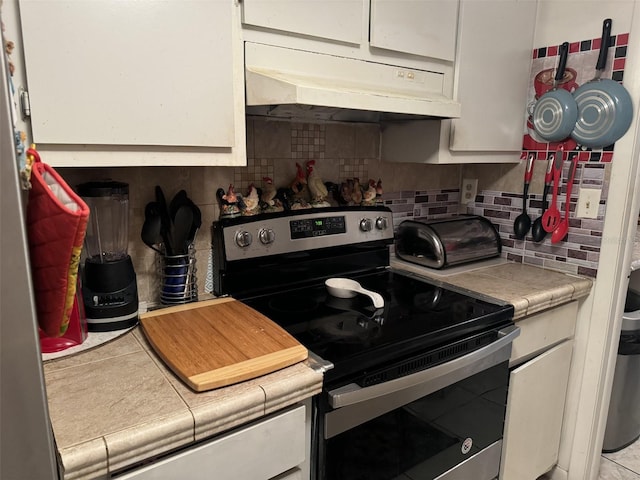 4029 E Sunflower Cir, Labelle, FL 33935 - kitchen featuring backsplash, electric range, and white cabinets