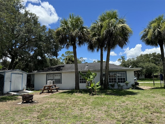 4029 E Sunflower Cir, Labelle, FL 33935 - rear view of property with a lawn, an outdoor fire pit, and a shed