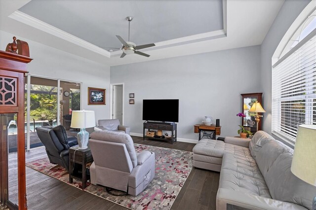 living room with dark hardwood / wood-style floors, ceiling fan, and a raised ceiling