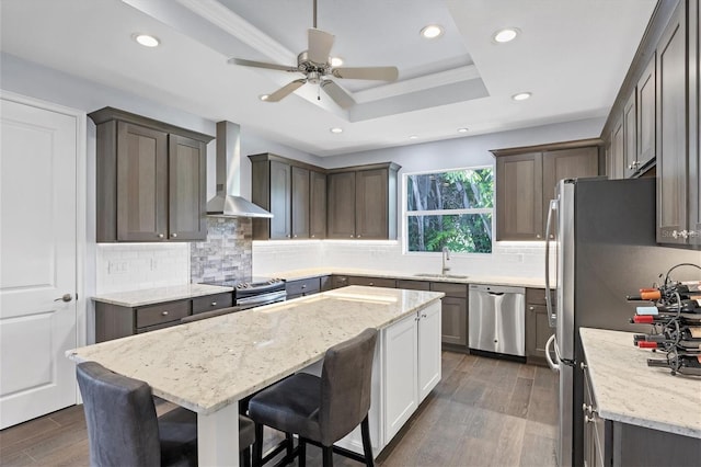 kitchen featuring a center island, dark hardwood / wood-style floors, stainless steel appliances, and wall chimney exhaust hood