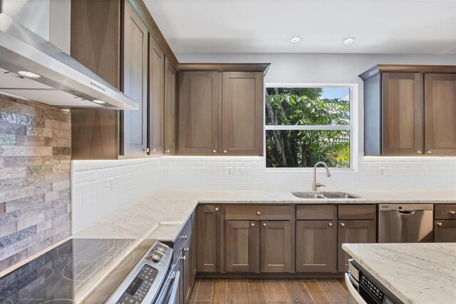 kitchen featuring sink, dishwasher, decorative backsplash, and wall chimney exhaust hood