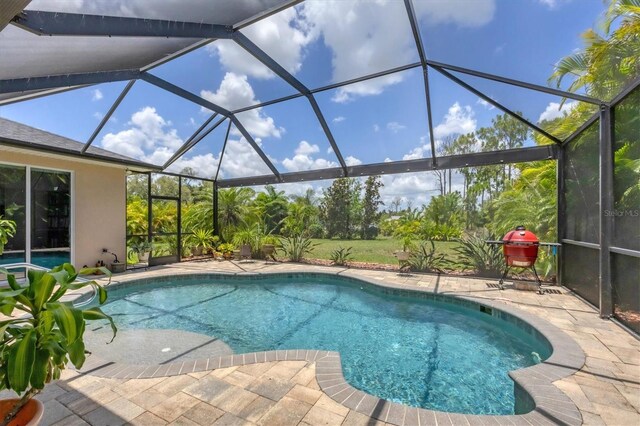 view of pool with a patio and glass enclosure