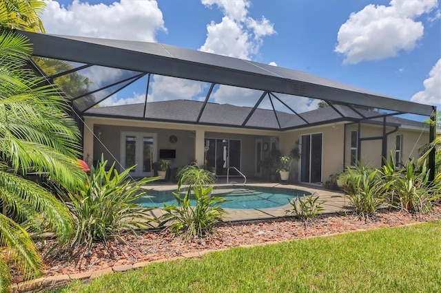 back of property with a patio area and glass enclosure