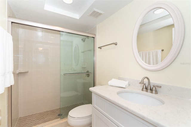 bathroom featuring vanity, toilet, and a shower with door