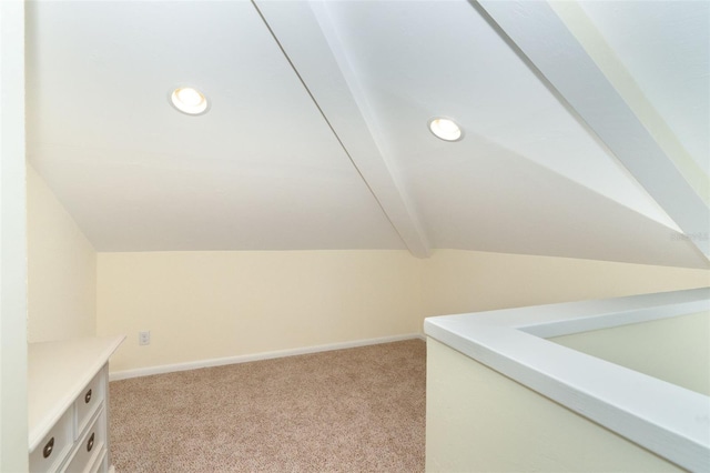 additional living space with light carpet and lofted ceiling with beams