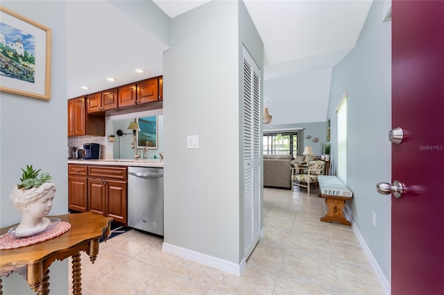 interior space with dishwasher, light tile patterned flooring, sink, and tasteful backsplash