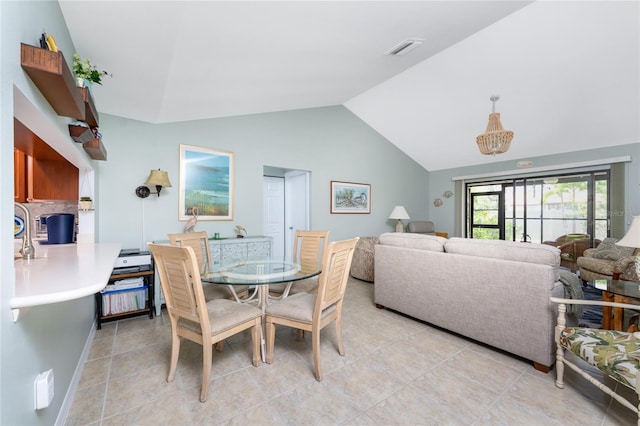 dining area featuring light tile patterned floors and vaulted ceiling