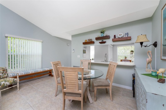 tiled dining area with vaulted ceiling