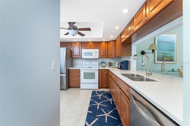 kitchen featuring ceiling fan, sink, backsplash, light tile patterned floors, and appliances with stainless steel finishes