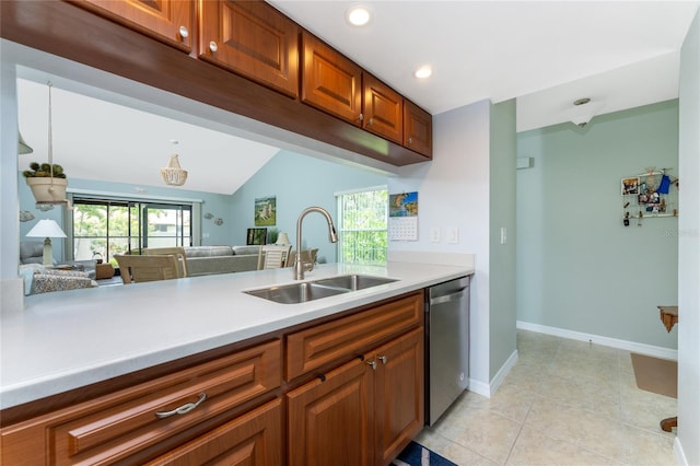 kitchen with dishwasher, sink, kitchen peninsula, vaulted ceiling, and light tile patterned floors